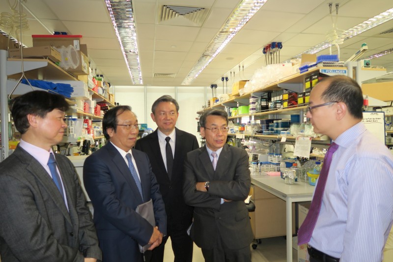 新加坡國立大學CHNG Wee Joo教授(右一)為李文華校長帶領導的參訪團介紹National University Cancer Institute的研究設施。