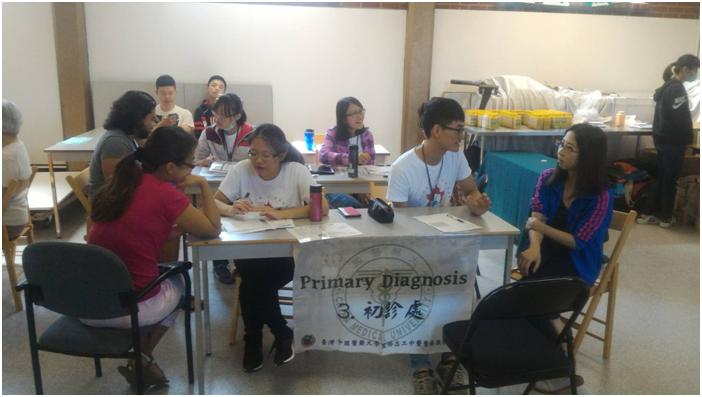 中國醫大國際志工中醫醫療服務隊替病患紀錄病例以供醫師參考。